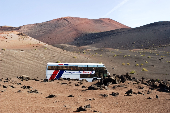 Busses follow the route of the Volcanoes through the badlands of Timanfaya National Park in Lanzarote, Spain