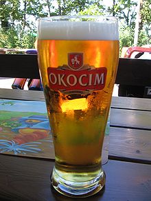 Glass with Okocim Lager on a table outdoor