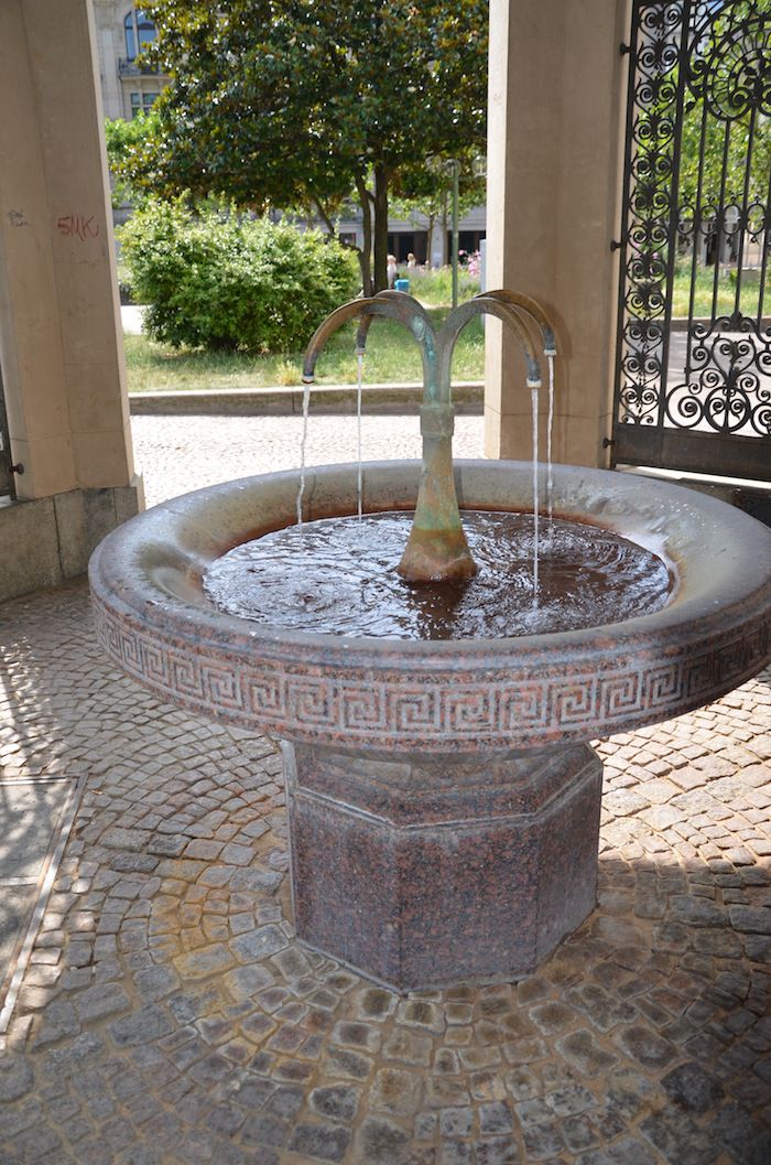 This fountain, called the trenkshalle, was built in 1887. warm water gushes out. the red deposits around the edge of the fountain don’t look appetizing