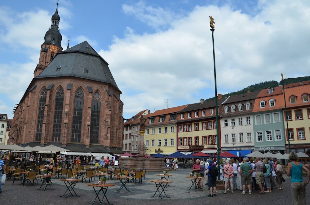 A red sandstone baroque church, the Heiliggeistkirche, looks somberly down on the square.