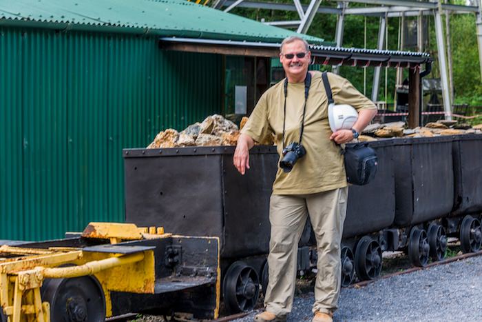 The author stands beside an ore cart loaded with ore from the gold mines.  