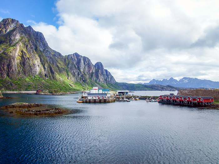 Fishing boats and boat houses backed by sheer mountain ranges in Svolvær 