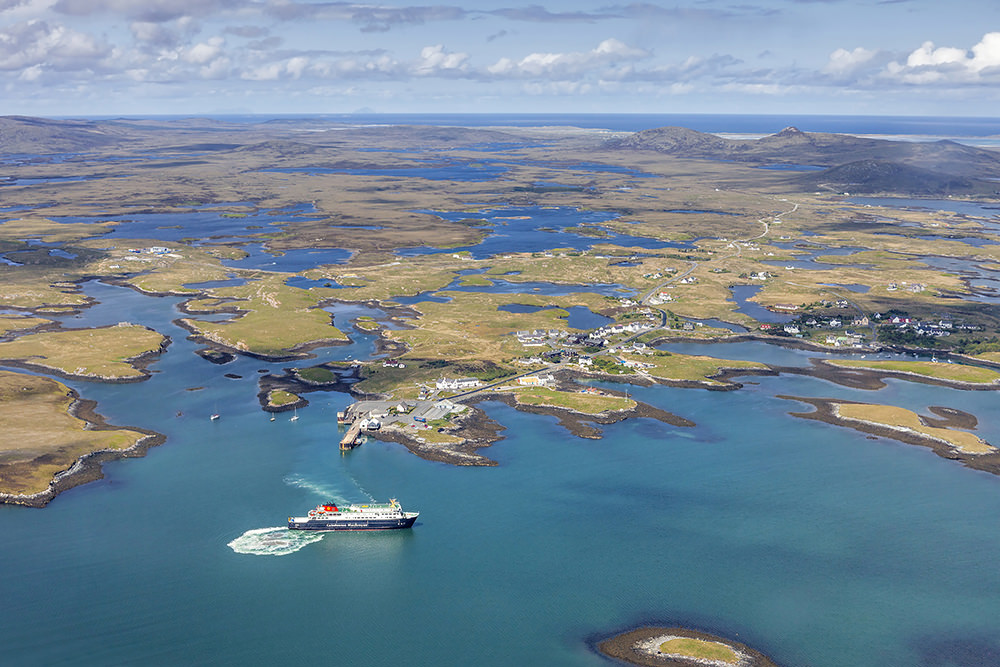 From above, Lochmaddy, the village capital of North Uist and the drowned eastern landscape of peat bogs and lochans — earth and water — stretching to the Atlantic coast in the distance. Once the haunt of pirates, it is now a special marine conservation area. (Courtesy: www.ruralnetwork.scot, © Peter Scott) 