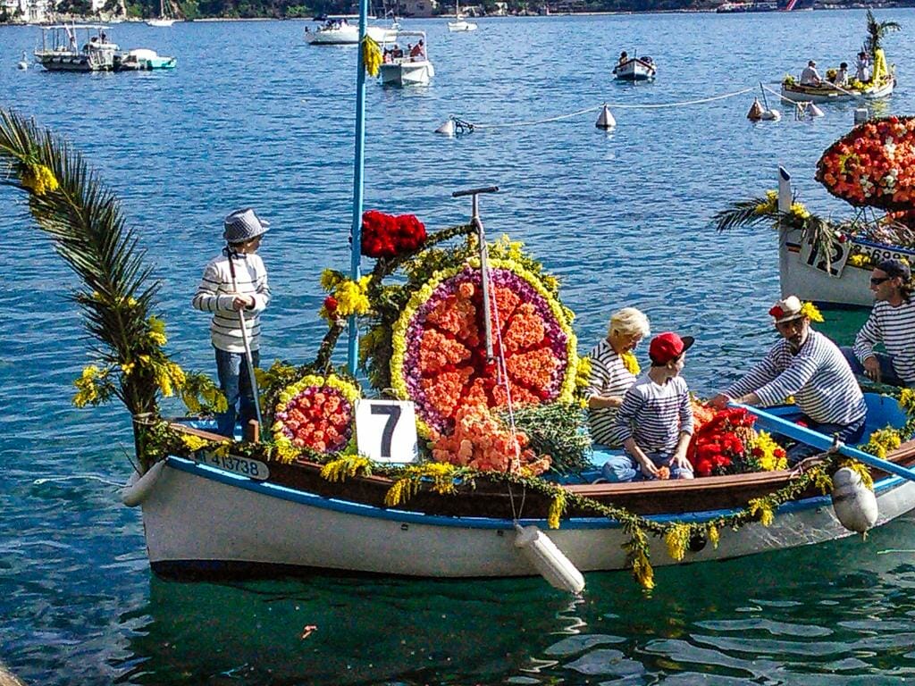 Beautifully decorated boats at the Battle of the Flowers in Villefranche-sur-Mer’s Battle of the Flowers (Combat Naval Fleuri)