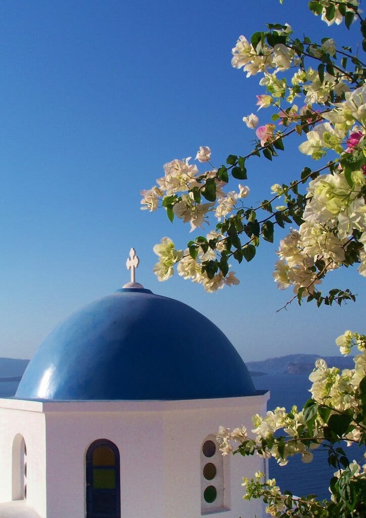 On a Trip to Santorini, the dome and white stucco of the Oia Santorini Church is a must see for the religious or secular