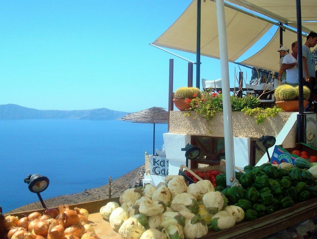 Produce displayed above an ocean view on a trip to Santorini