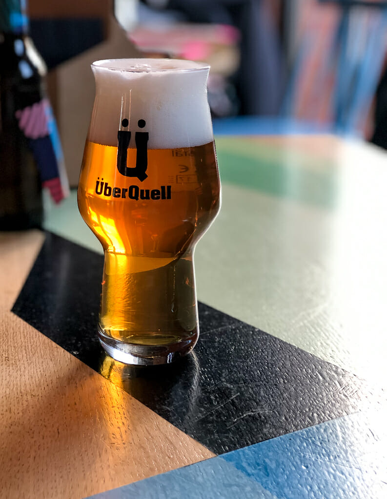 Glass of Überquell Beer on Table - Überquell Brewery - What to do in Hamburg
