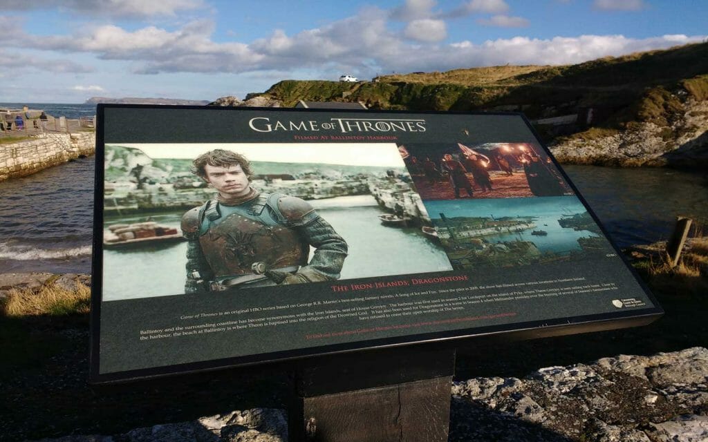 Tourist sign in Ballintoy Harbor with information about where Game of Thrones was filmed