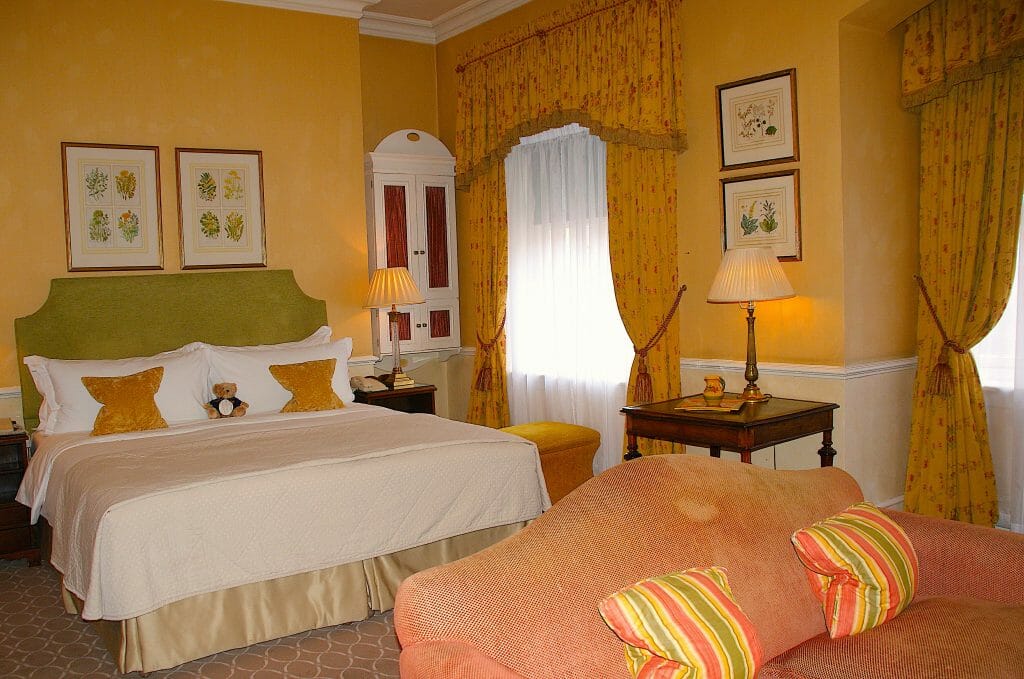 Bedroom in the Draycott with yellow walls and a pink couch