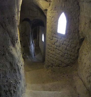 Caves underneath the castle with sunlight peaking into the sparse windows