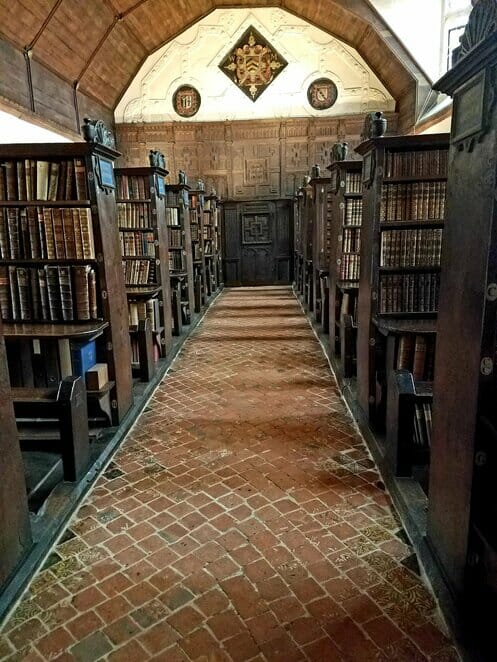 View down a main aisle with peaks of the chained books in Merton College Upper Library