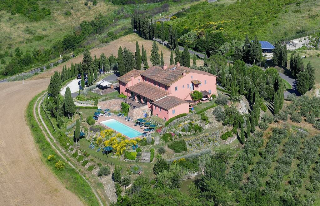Aerial view of a luxurious villa with a mass of garden and a huge pool