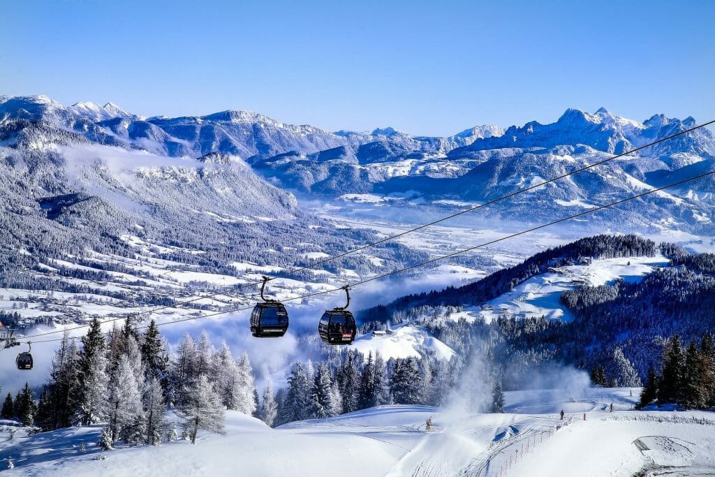 Ski lifts gliding over the perfect ski slopes surrounded by snow dusted pine trees