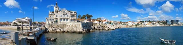 View of the coast of Cascais Portugal with boats leisurely sailing past the buildings