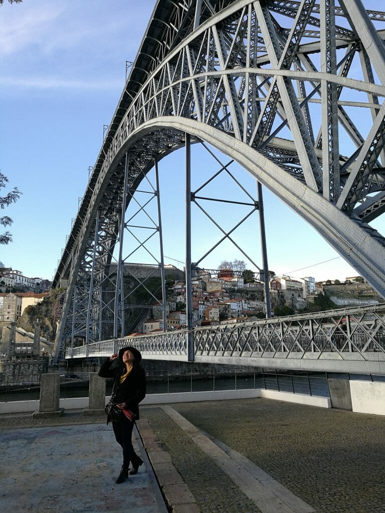 Woman standing at the very bottom of the bridge, smiling and looking up in wonder