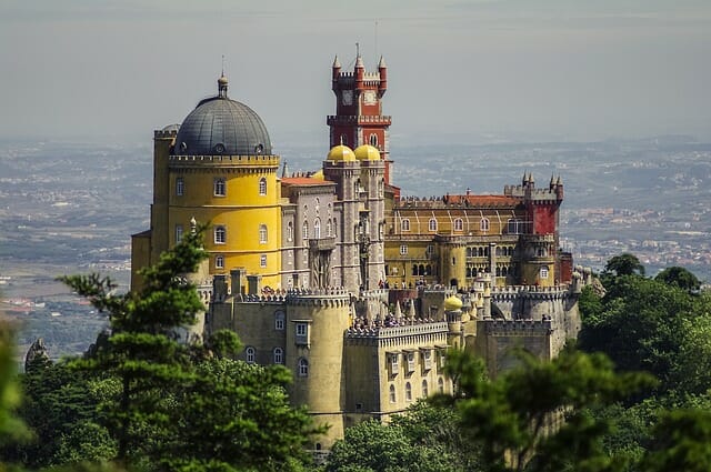 Yellow, red, and tan castle overlooking Portugal on its regal perch