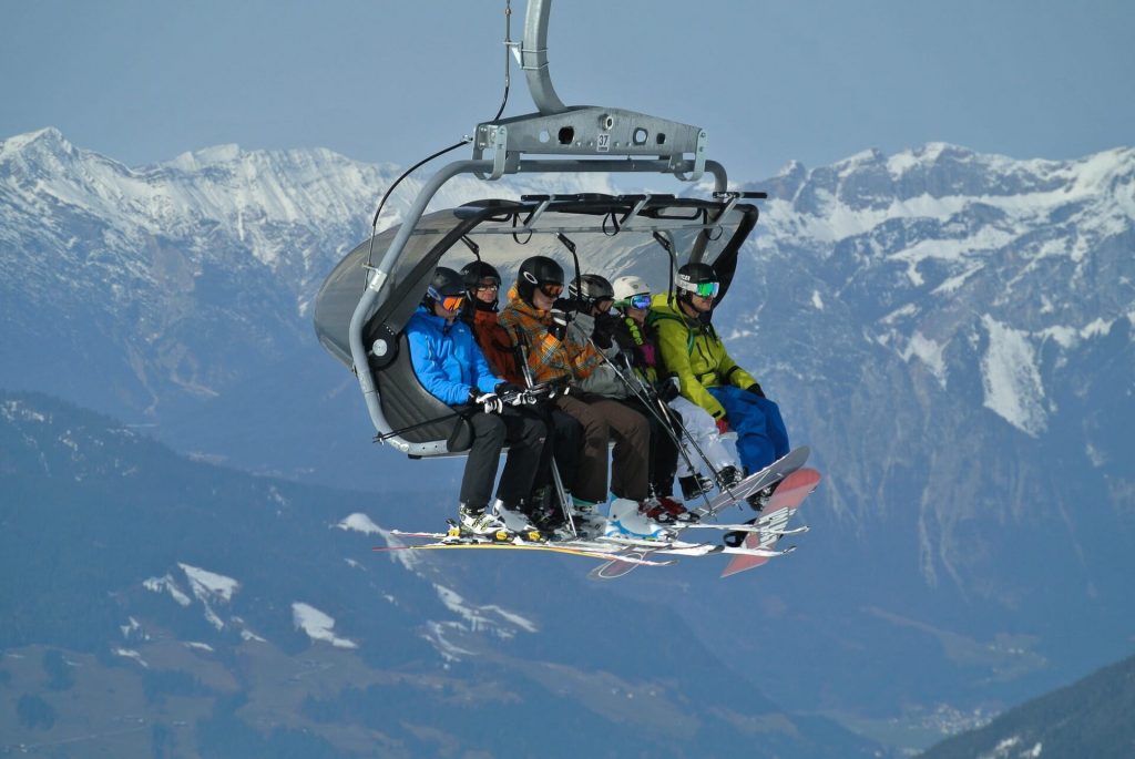 Six people packed on a ski lift, ready to get off