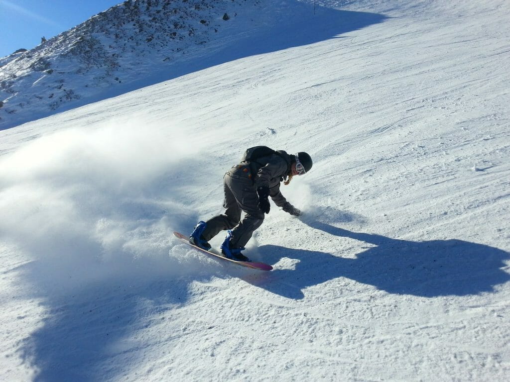 Man taking a swift turn on his snowboard