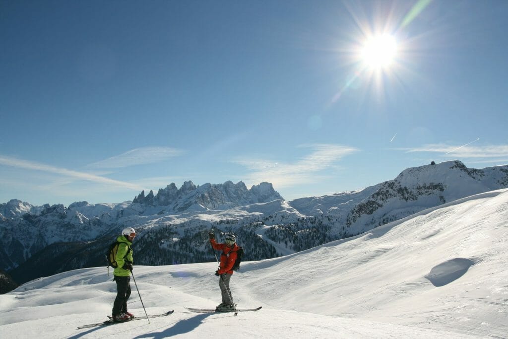 Two skiers on the Dolomite slopes of Italy on a sunny day