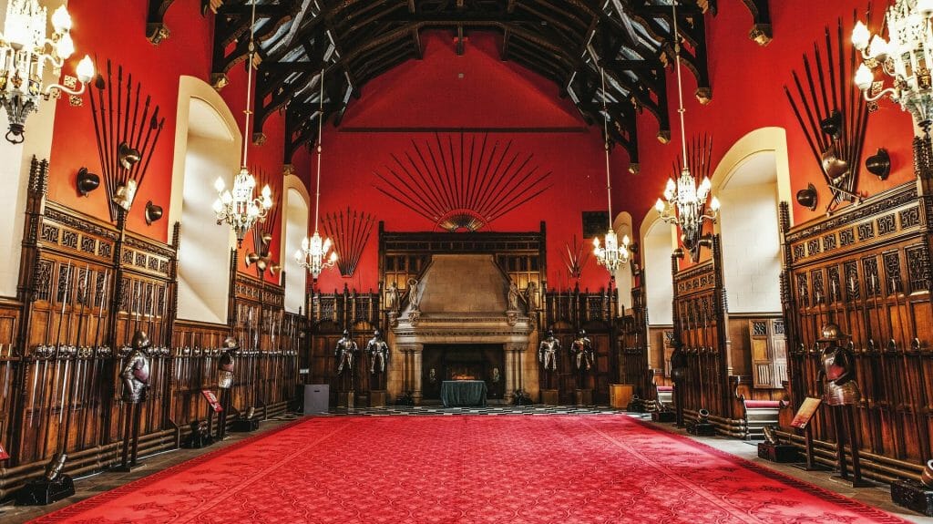 Inside Edinburgh castle, red room with brown detailing and an unlit fireplace
