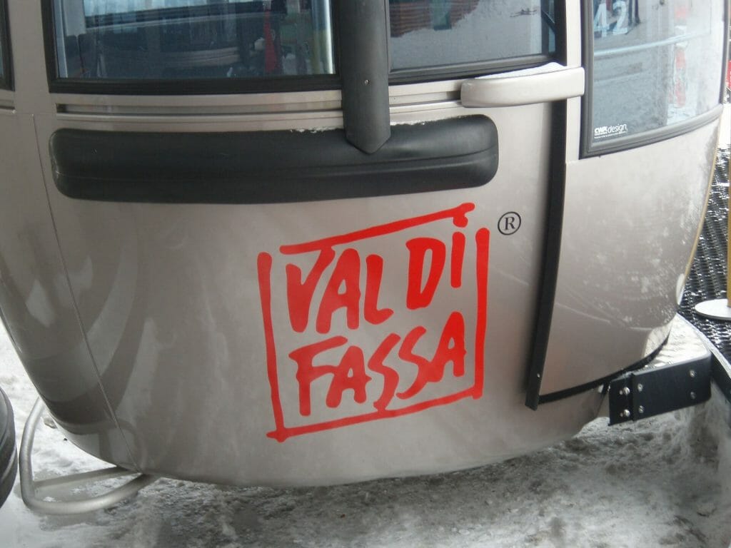 Chair lift with the words Val Di Fassa in bright red