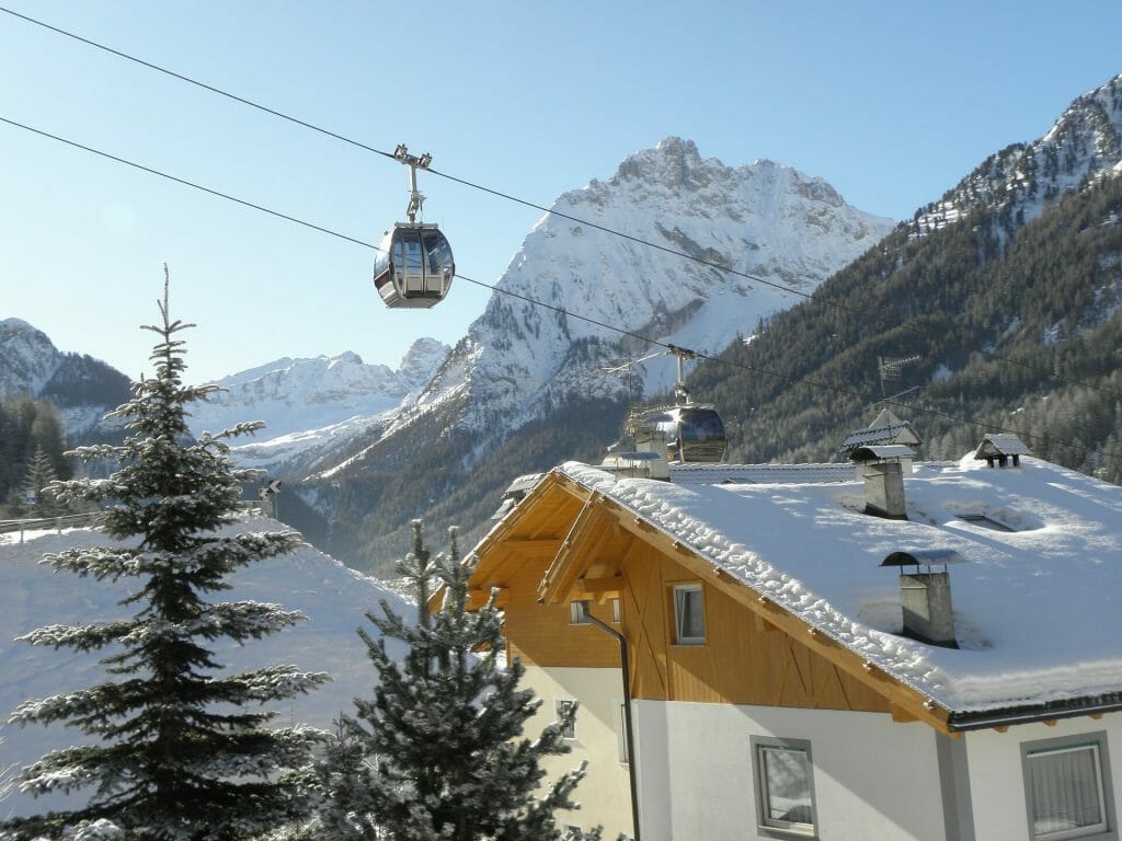 Ski lifts going over a beautiful ski chalet in Val Di Fassa Italy