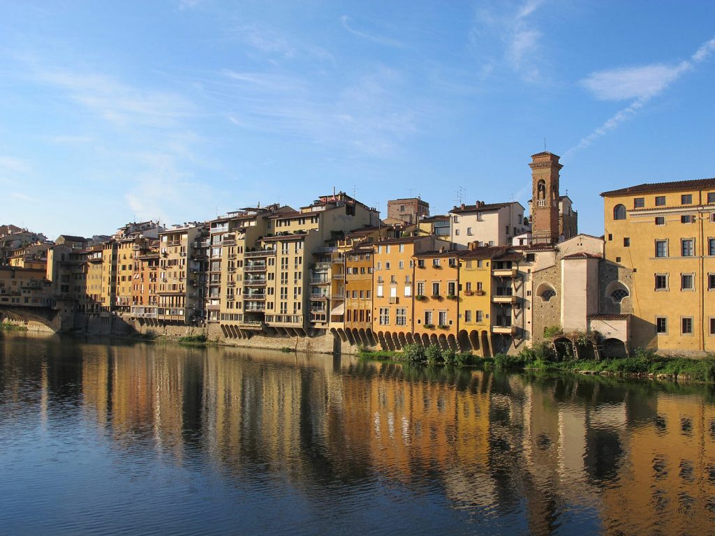 River reflecting the varying beige building back on the sunny day in Florence