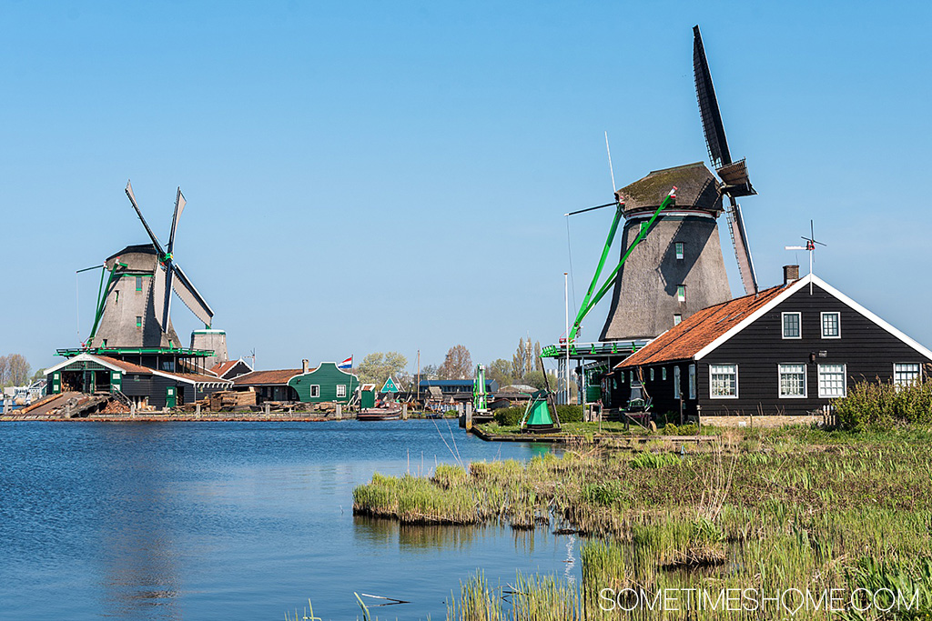 River by towering, old windmills on a sunny day