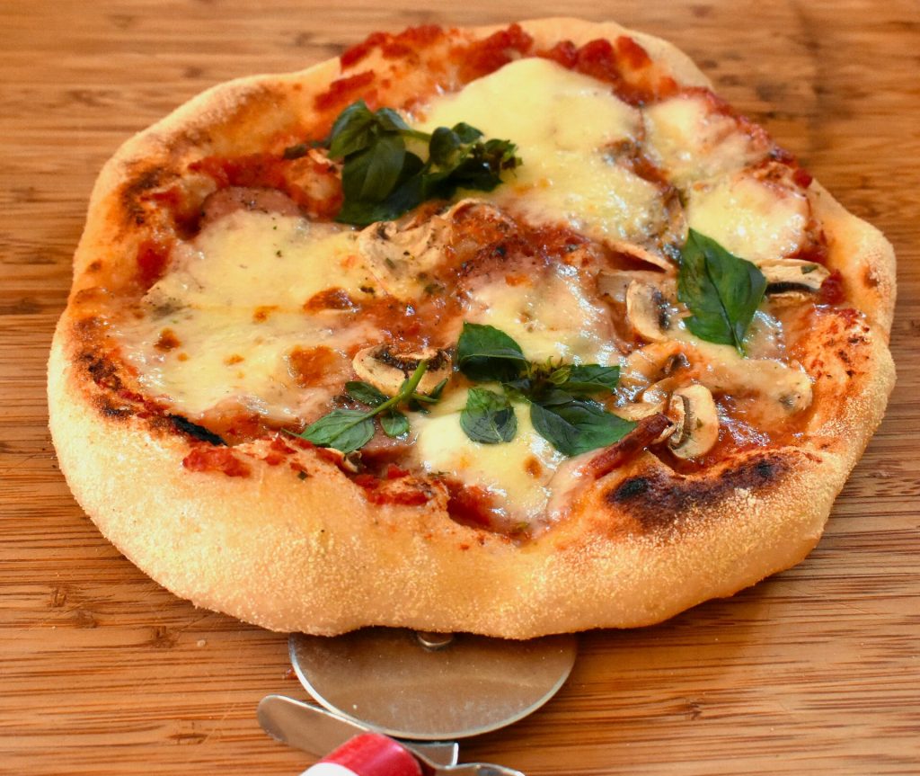 Individual pizza topped with fresh mozzarella, tomato sauce, and basil