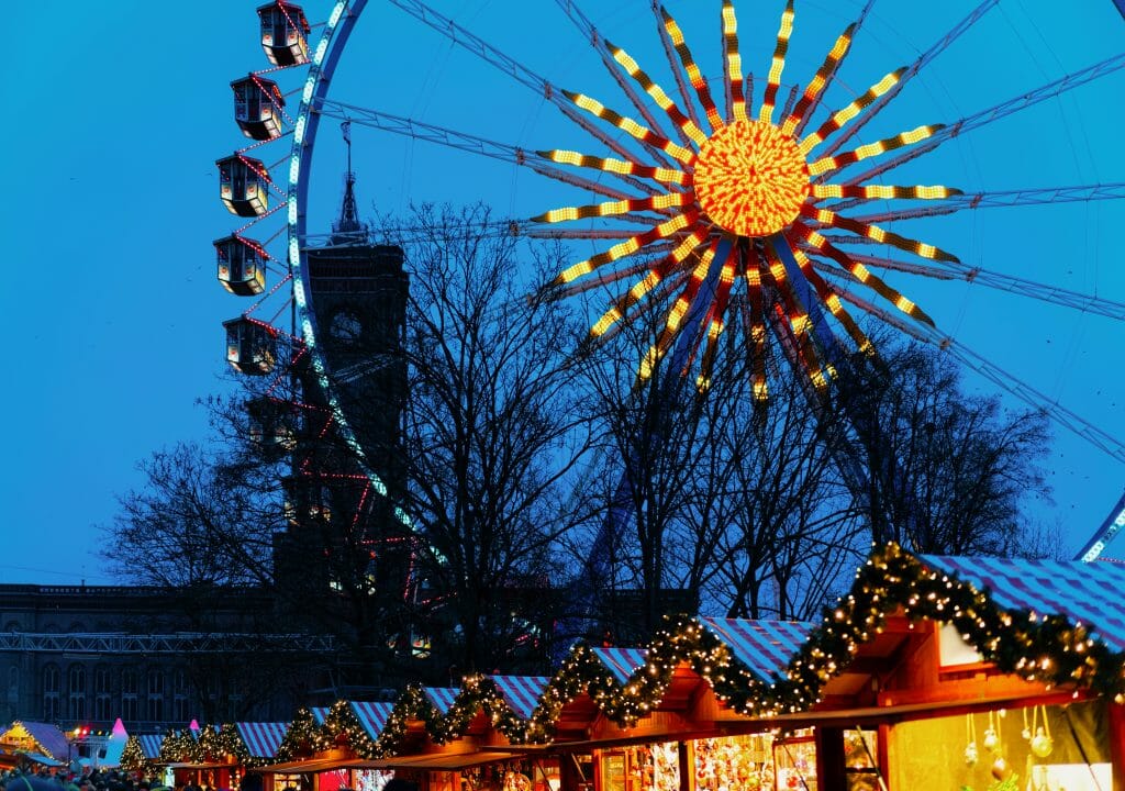 Ferris Wheel glowing above the Christmas market stalls at the Berlin Town Hall