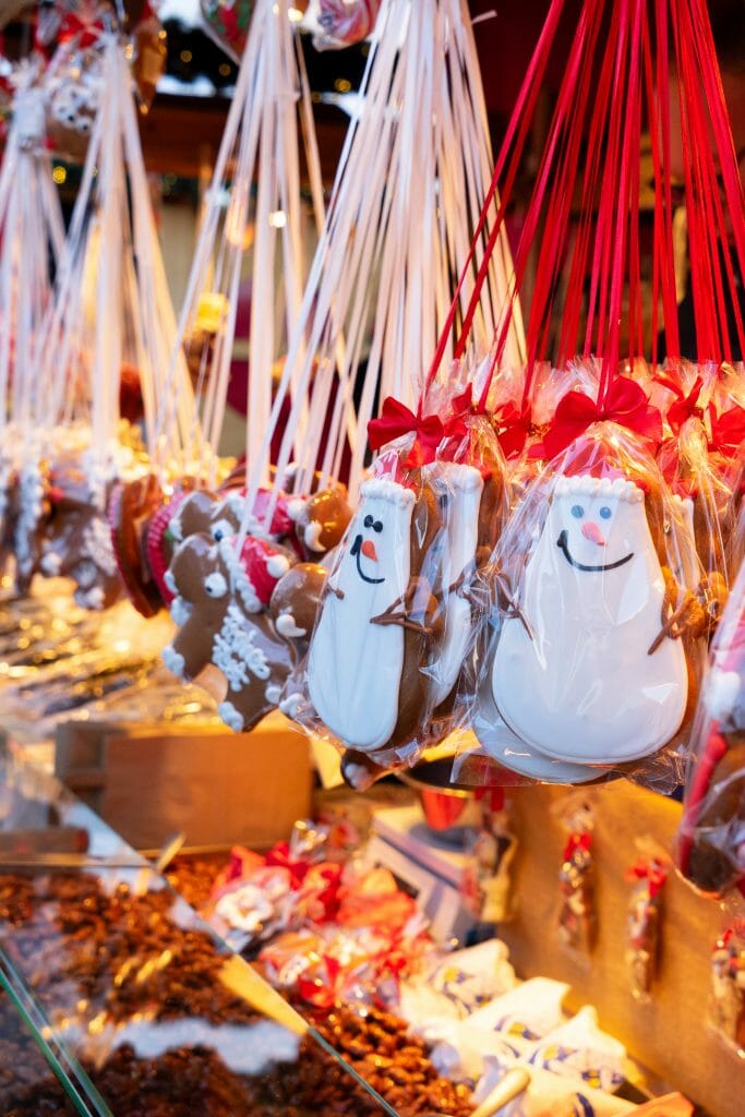 Gingerbread cookies decorated as snowmen hanging from a rod