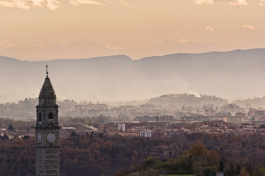 Sun setting over the quiet village of Piemonte with its churchs bell tower peaking over the rest of the dark buildings