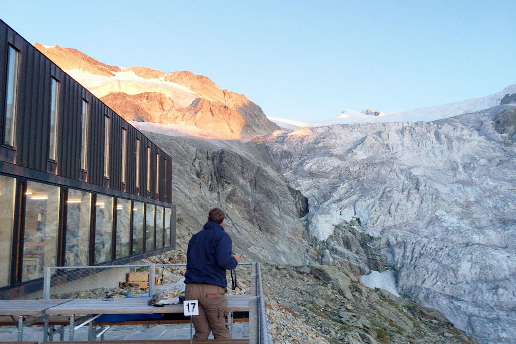 Man standing on terrace overlooking the Swiss alps