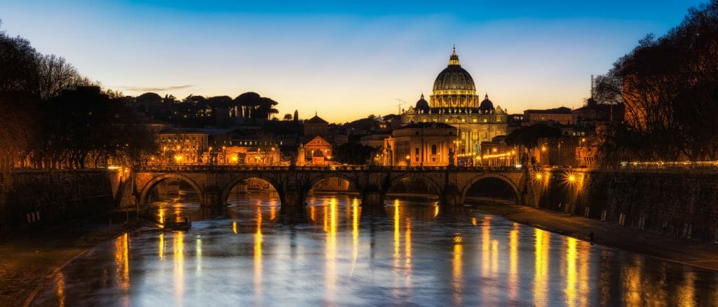 River Tiber with bridges and St Peters Basilica in the background at dusk - Italy Itineraries