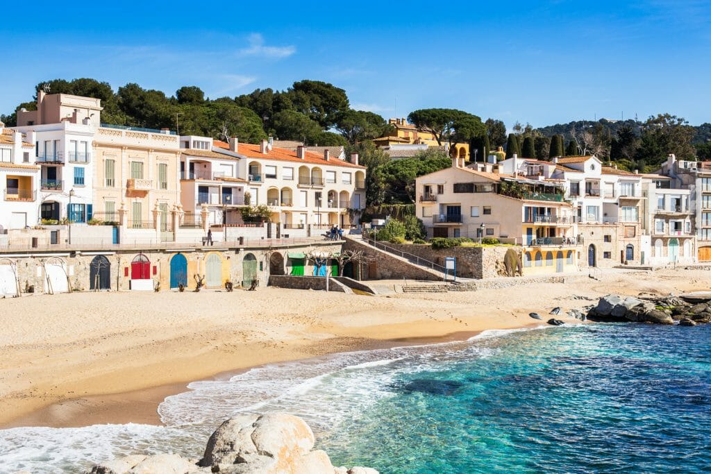 Calella de Palafrugell Beach with white small houses, sandy beach and clear turquoise water, Costa Brava.