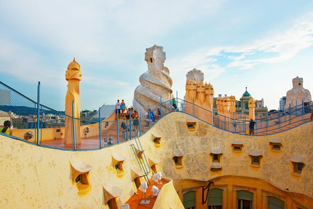 Roof  with chimneys and tourists in Casa Mila building in Barcelona in Spain. Also called as La Pedrera, or Miracle Home, or The Quarry. Designed by Antoni Gaudi