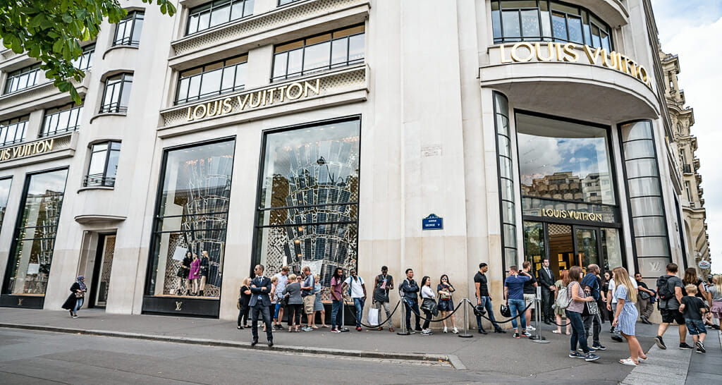 People standing in line in front of Louis Vuitton Store on Champs Elysées in Paris