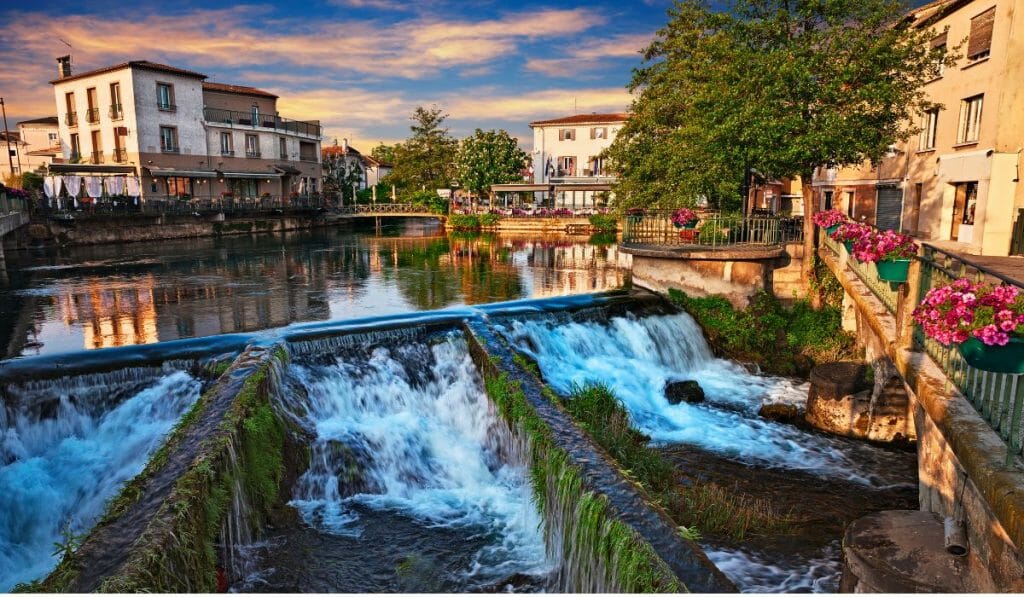 Small manmade waterfall on small river in L'isle sur la sorgue during sunset