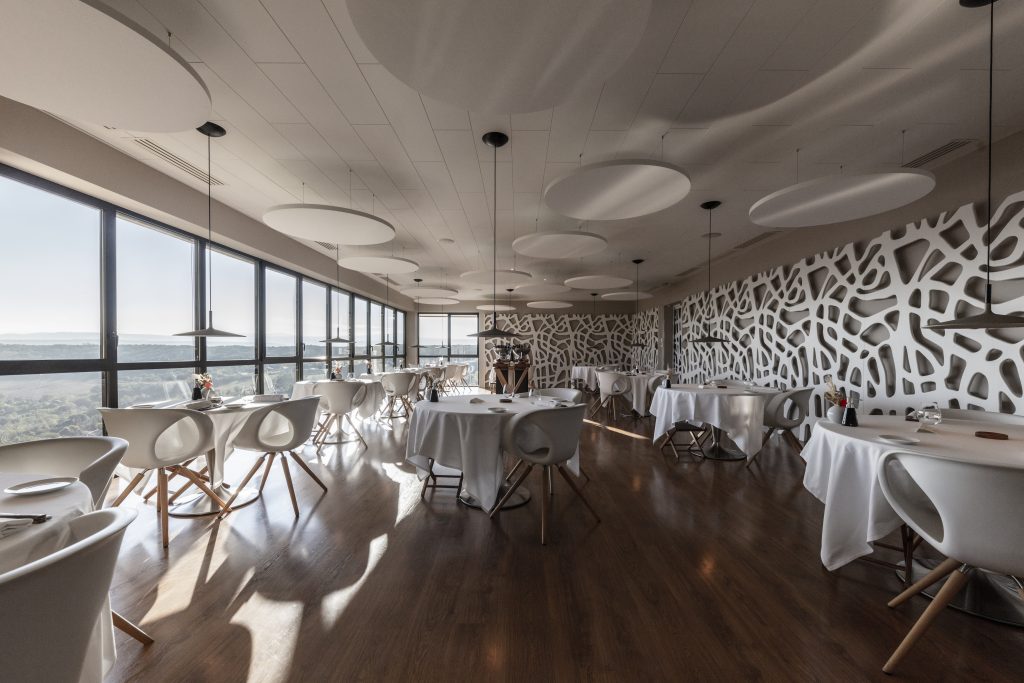 Origines Restaurant - modern dining room with wall to ceiling windows on the left overlooking the hills of auvergne