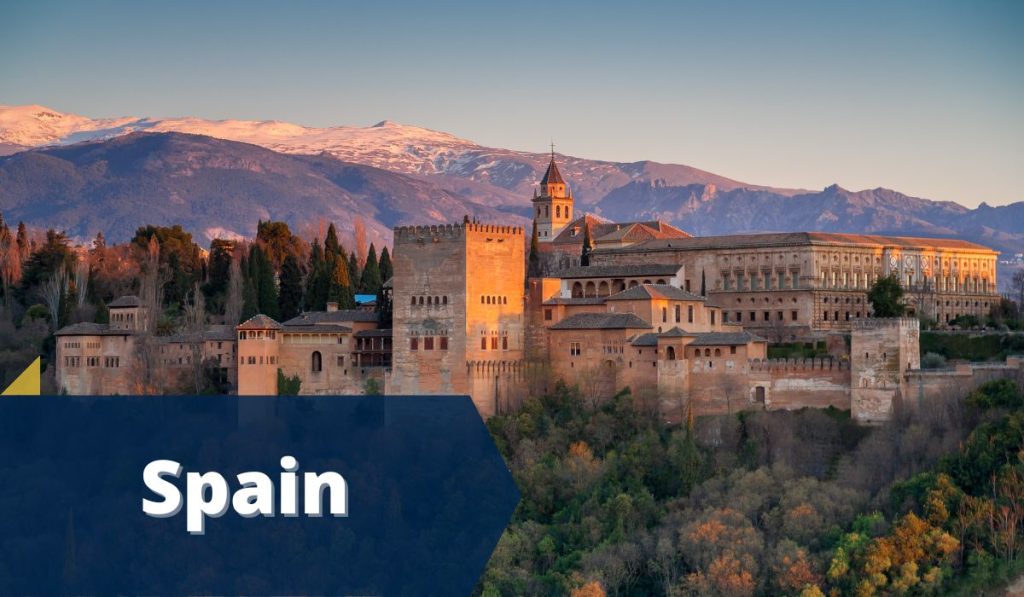 Historic Castle in Granada Spain during sunset with blue banner in the bottom left corner with white text Spain
