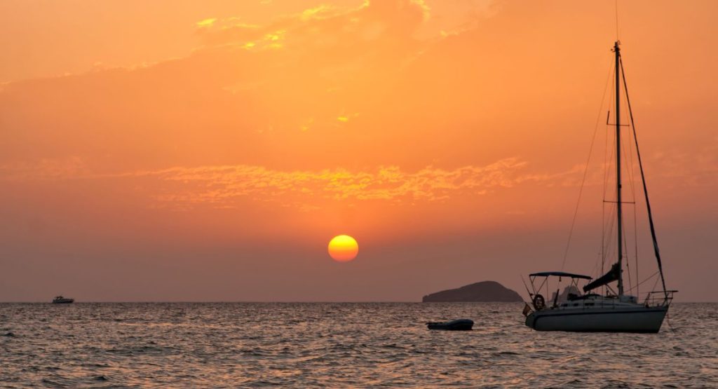 Sailboat on Mediterranean Sea during sunset in Ibiza. Yoga retreat Ibiza.
