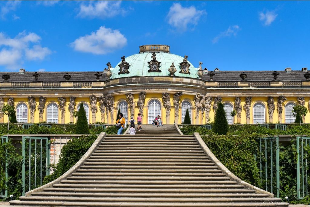 Sanssouci Palace Potsdam - Yellow Baroque building with wide staircase and gardens