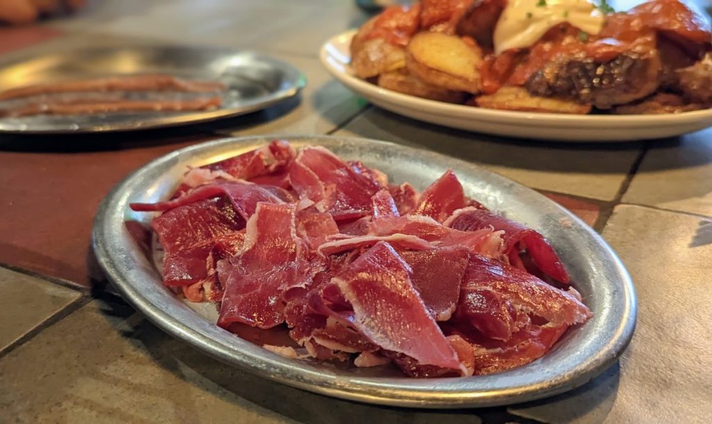 metal plate with sliced jamon iberico - traditional  Northern Spain Food and Spanish tapas in Barcelona
