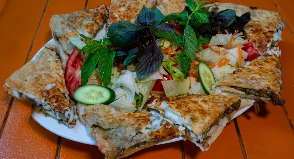 gözleme, a Central Anatolian pastry consisting of flatbread and varying savory fillings, including meat, cheese, spinach, and potato on a plate